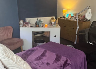 Cozy Beautylicious treatment room in Poole, England, GB with plush bed and ambient lighting.