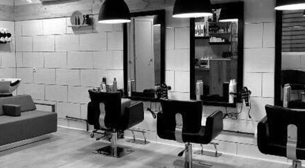Interior moderno de Pelokas Hair Salon en Torrent, Comunidad Valenciana, ES con sillas y espejos elegantes.