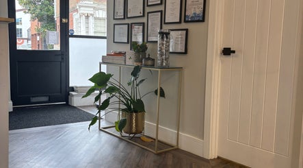 Stylish entry with plant and diplomas at Amy Salmon Aesthetics, Ware, England, GB.