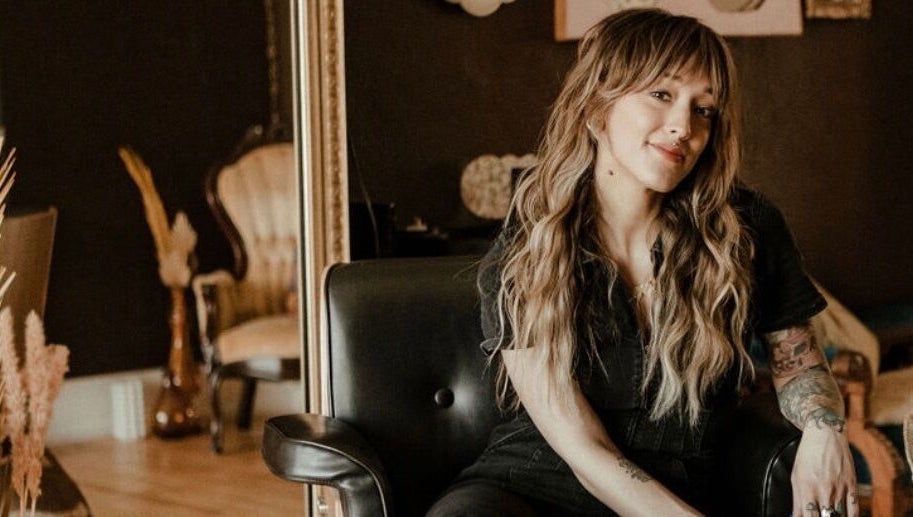 Stylist at Third Hand Salon in Rock Island, Illinois, US, showcasing elegant hair and tattoo art.