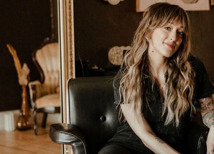 Stylist at Third Hand Salon in Rock Island, Illinois, US, showcasing elegant hair and tattoo art.