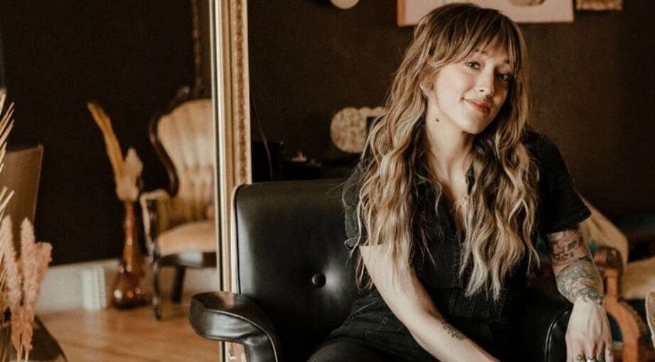 Stylist at Third Hand Salon in Rock Island, Illinois, US, showcasing elegant hair and tattoo art.