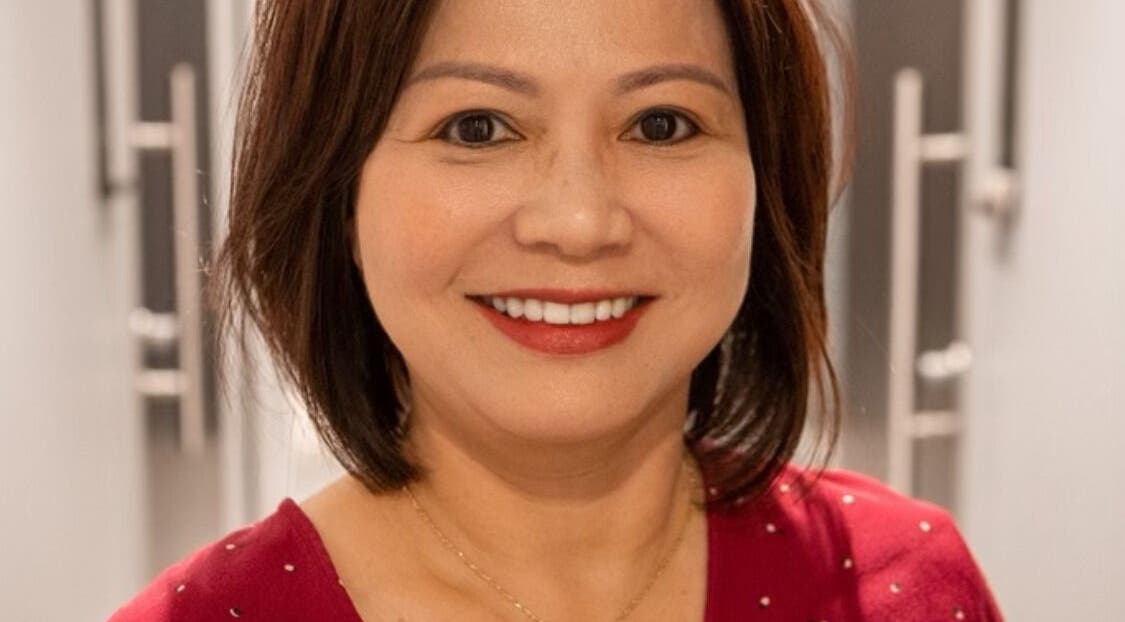 Smiling woman at JEN Salon from Salon Lofts in Fairfax, Virginia, US, highlighting beauty and wellness.