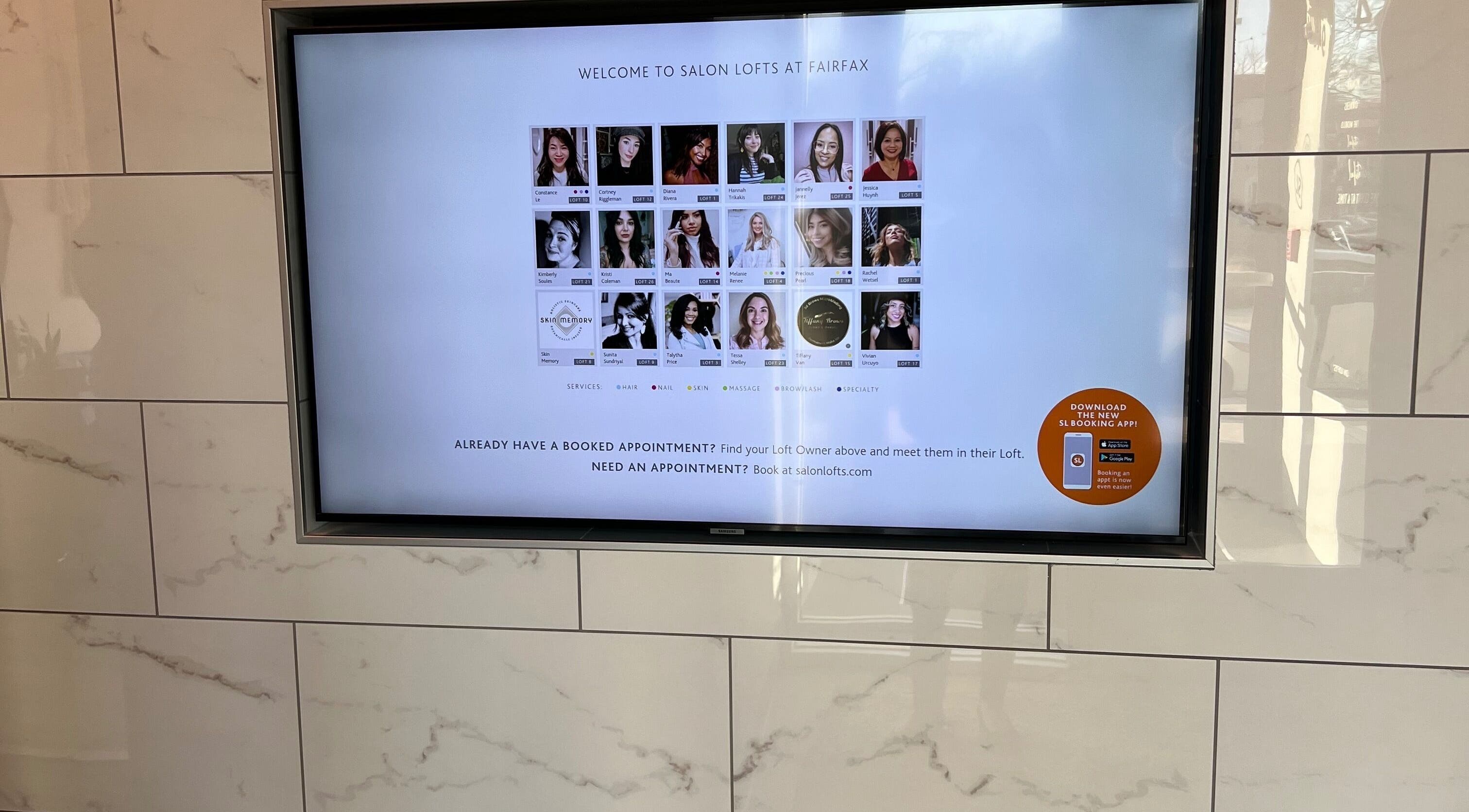 Digital screen at JEN Salon from Salon Lofts in Fairfax, Virginia, US displaying welcome message and stylist options.