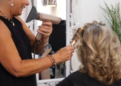 Stylist performing a blowout at Beachbums Tanning & Hair Bribie, Bongaree, Queensland, AU.