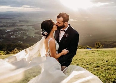 Couple kisses at sunset on a hill near Beachbums Tanning & Hair Bribie, Bongaree, Queensland, AU.