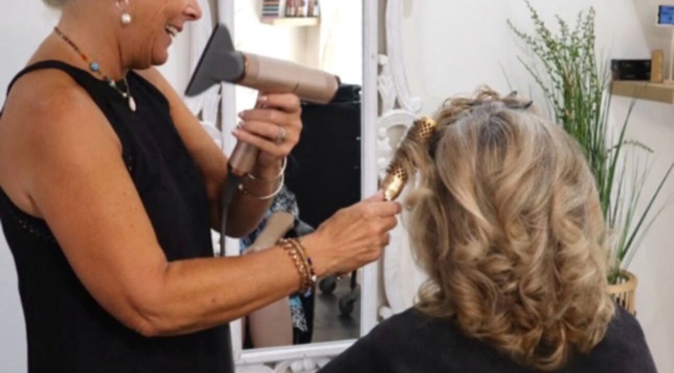 Stylist perfecting curls at Beachbums Tanning & Hair Bribie, Bongaree, Queensland, AU.