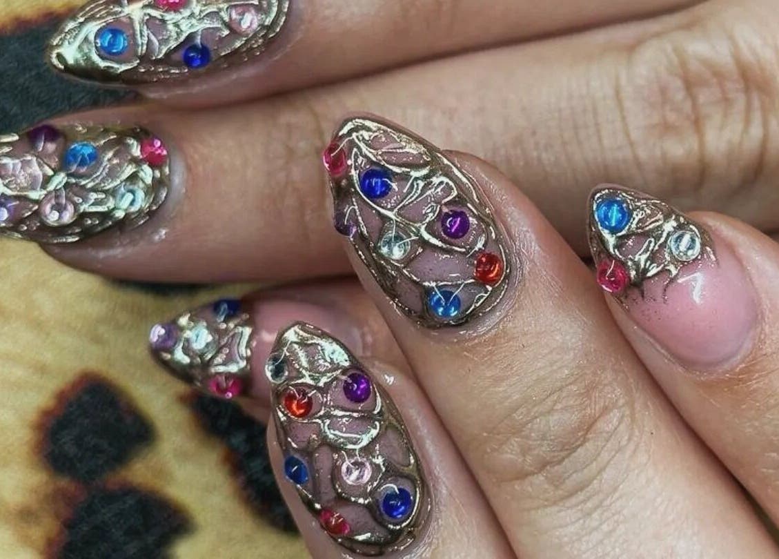 Intricate jeweled nail art at Cute But Deadly nail co. Bathgate, Scotland, GB showcases vibrant colors and designs.