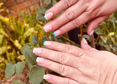 Elegant floral French manicure from The Nail Bazar in Randburg, Gauteng, ZA, with vibrant garden background.