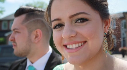 Smiling woman with elegant earrings at The Enchanted Beautician, Kincardine, Ontario, CA.