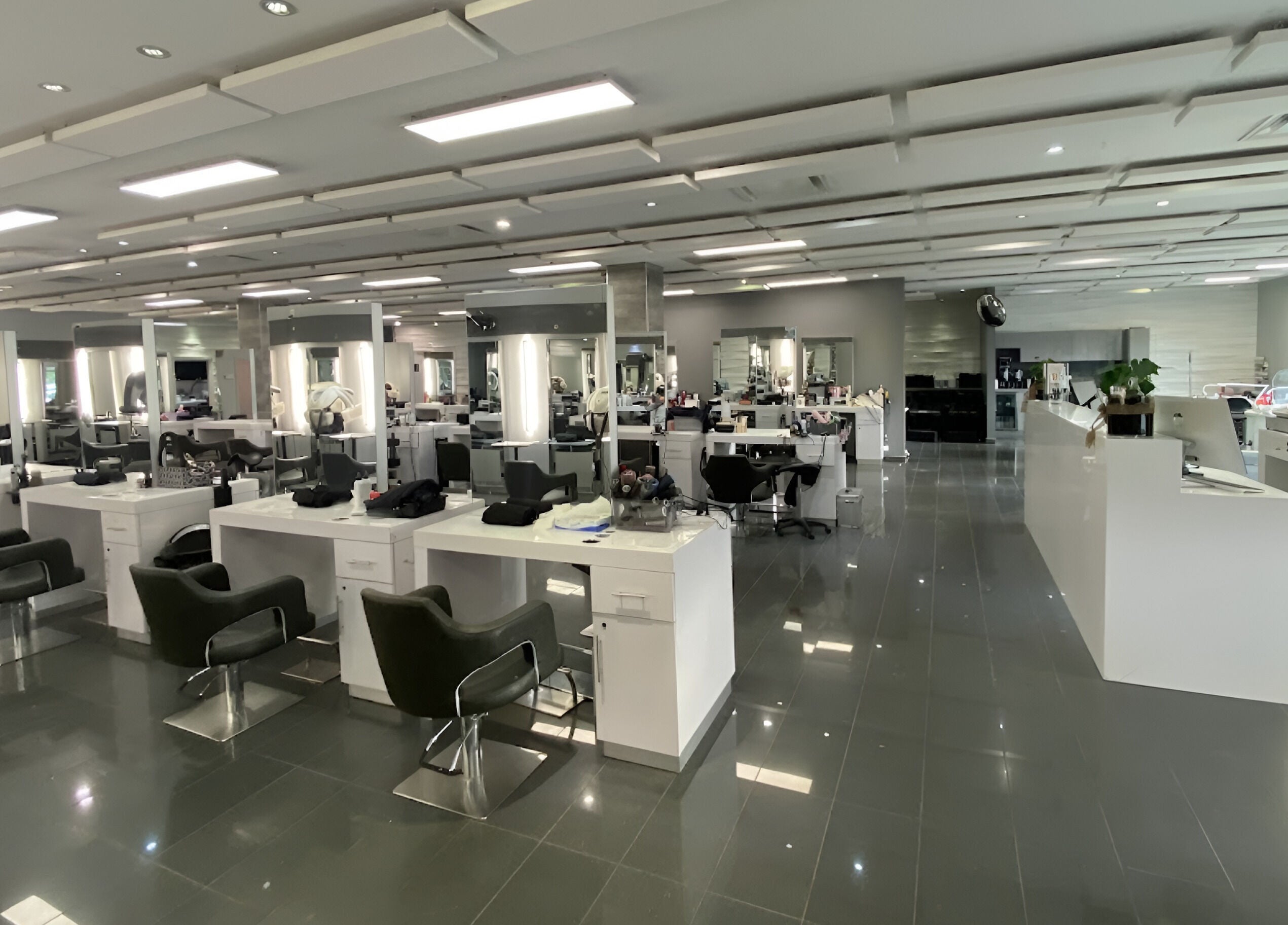 Intérieur moderne de St. Laurent Tendances Beauté à Laval, Québec, CA. Stations de coiffure alignées et lumineuses.