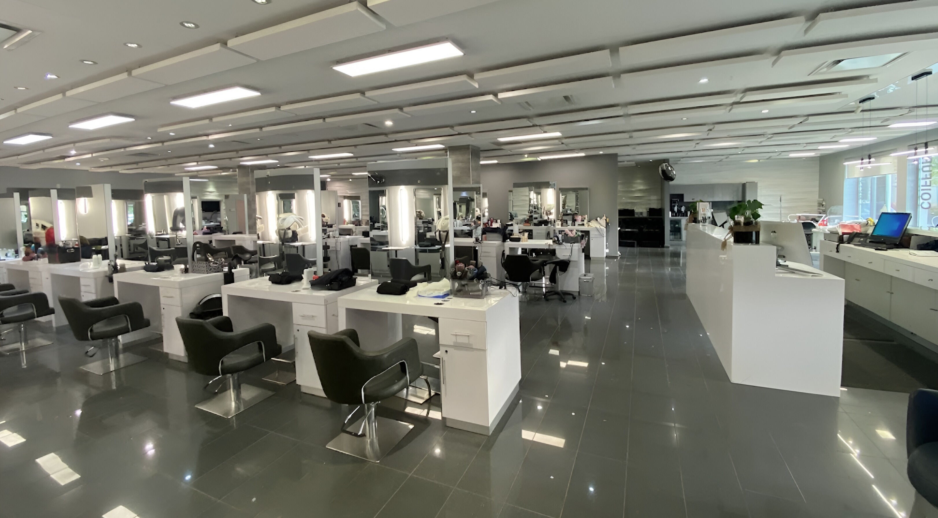 Intérieur moderne de St. Laurent Tendances Beauté à Laval, Québec, CA. Stations de coiffure alignées et lumineuses.