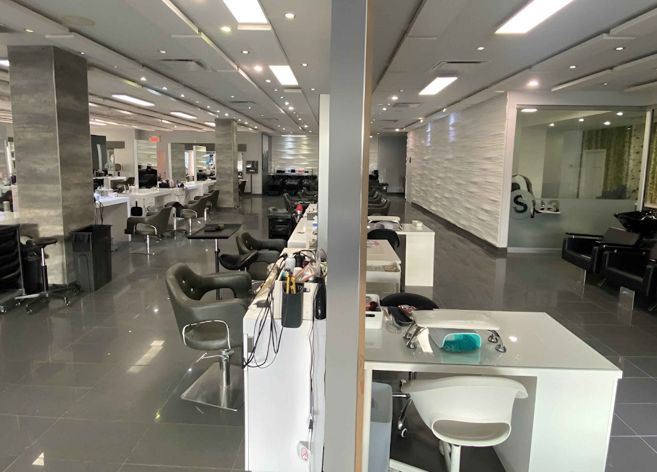 Intérieur moderne de St. Laurent Tendances Beauté à Laval, Québec, CA, montrant des stations de coiffure élégantes.