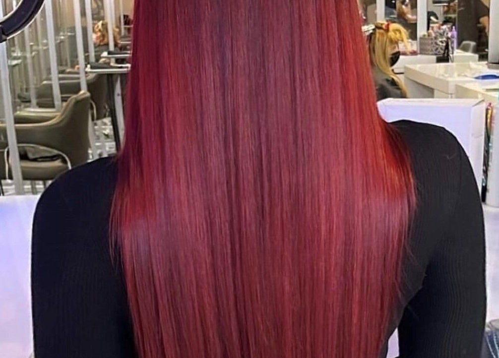 Cheveux écarlates lisses chez St. Laurent Tendances Beauté, Laval, Québec, CA, ambiance élégante et moderne.