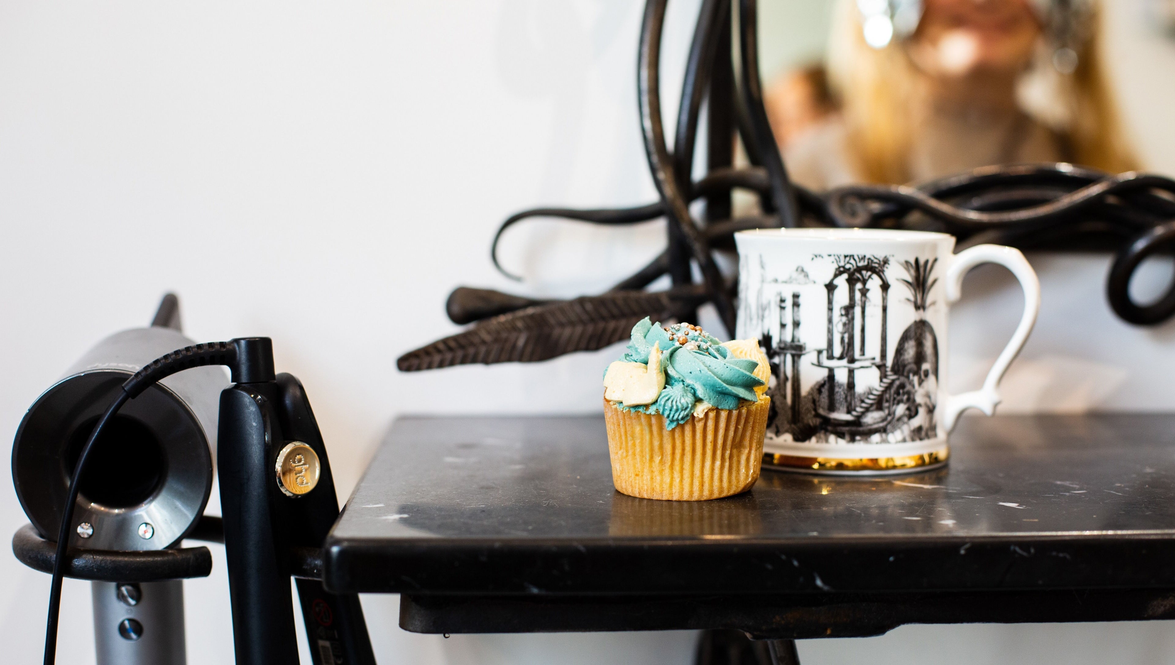 A chic salon scene at Tara’s Beautique, Bristol, England, GB featuring a cupcake and hairdryer.