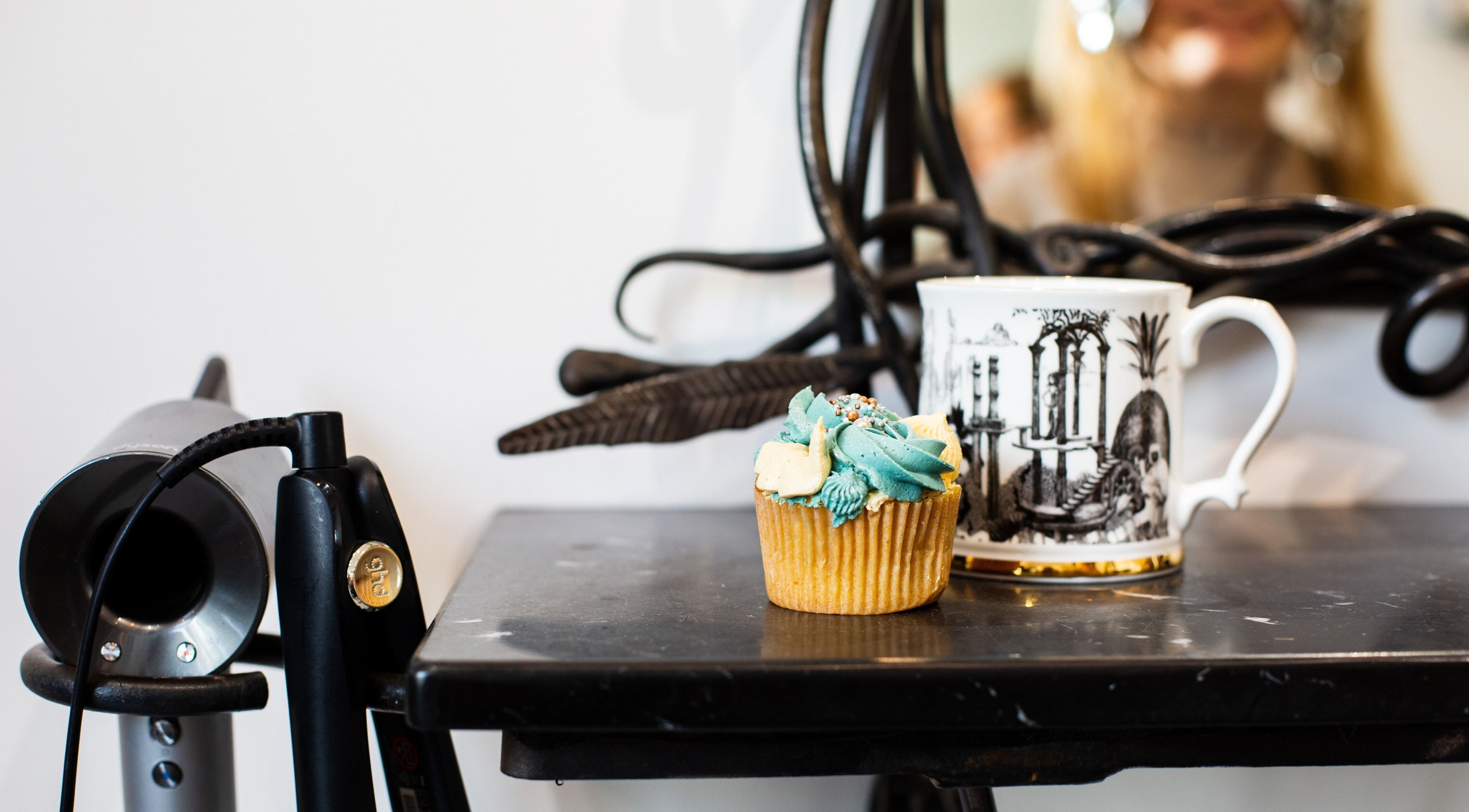 A chic salon scene at Tara’s Beautique, Bristol, England, GB featuring a cupcake and hairdryer.