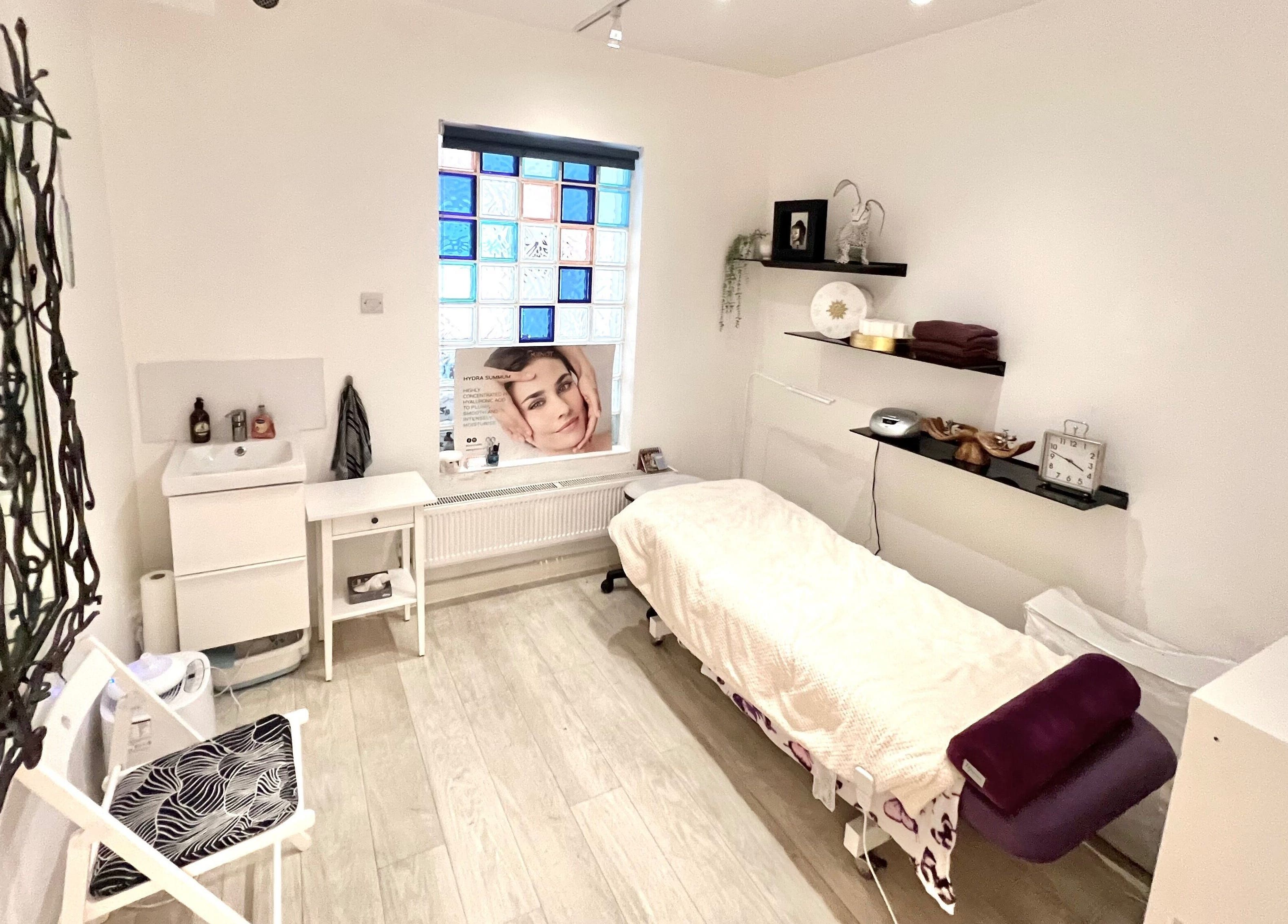 Calming treatment room at Tara’s Beautique, Bristol, England, GB, featuring a massage bed and elegant decor.