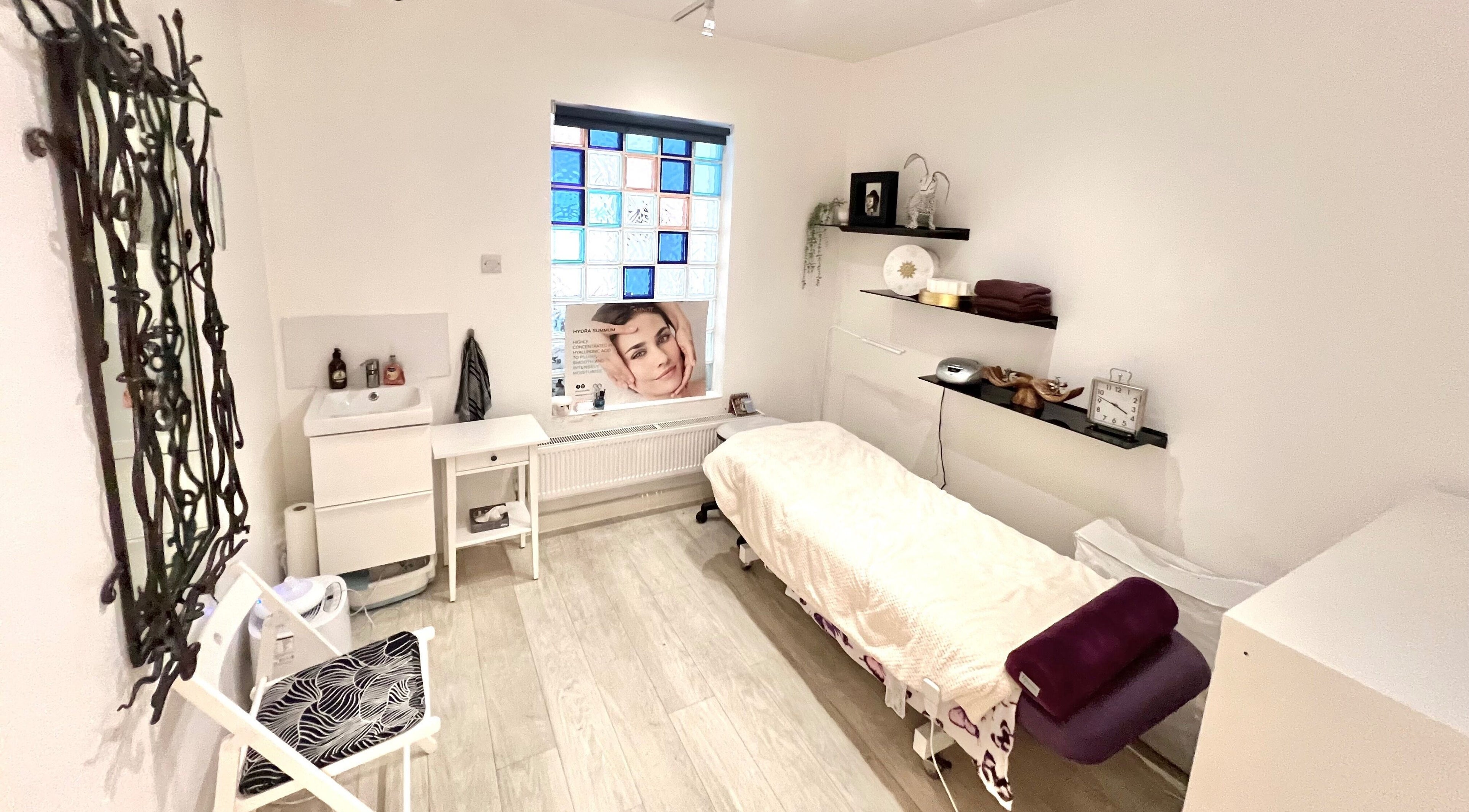 Calming treatment room at Tara’s Beautique, Bristol, England, GB, featuring a massage bed and elegant decor.