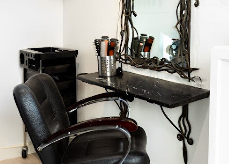 Elegant salon styling station at Tara’s Beautique, Bristol, England, GB. Modern chair, mirror, and hair tools.