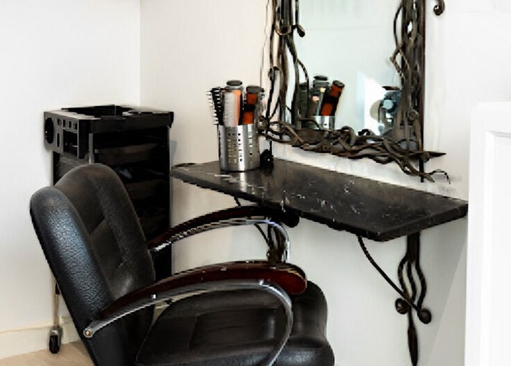 Elegant salon styling station at Tara’s Beautique, Bristol, England, GB. Modern chair, mirror, and hair tools.