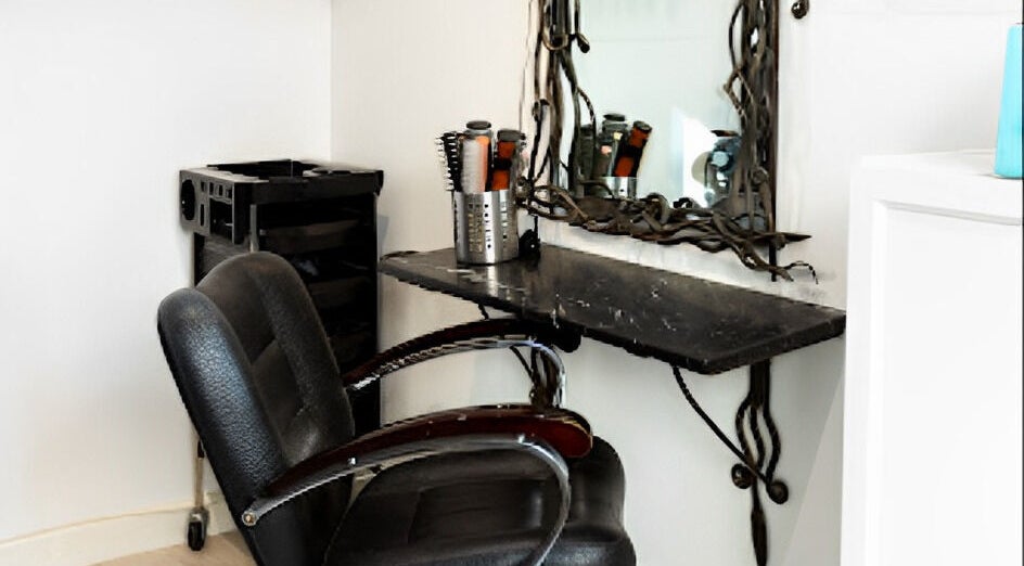 Elegant salon styling station at Tara’s Beautique, Bristol, England, GB. Modern chair, mirror, and hair tools.