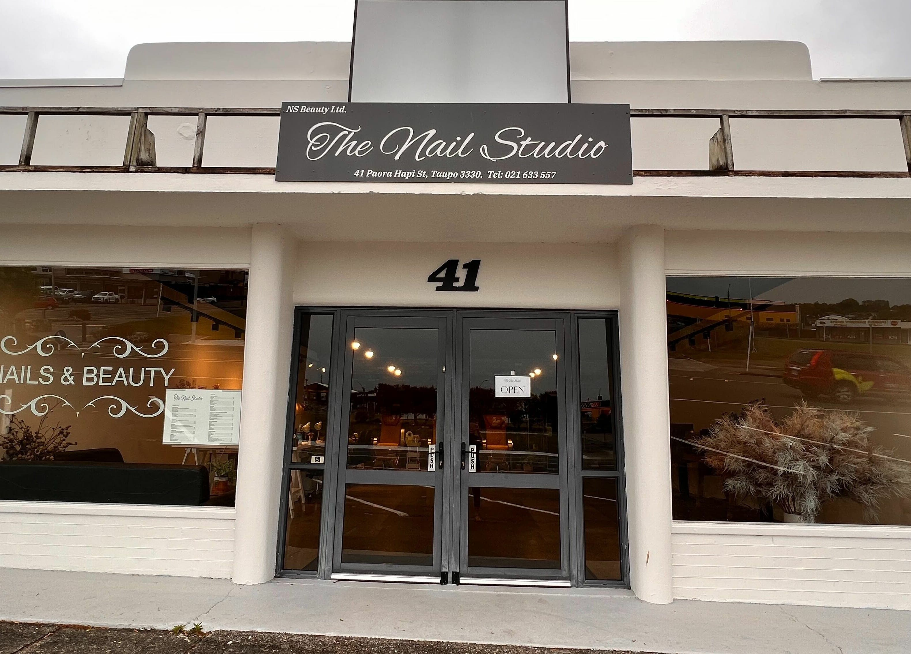 Entrance to The Nail Studio in Taupō, Waikato, NZ showcasing elegant glass doors and stylish signage.