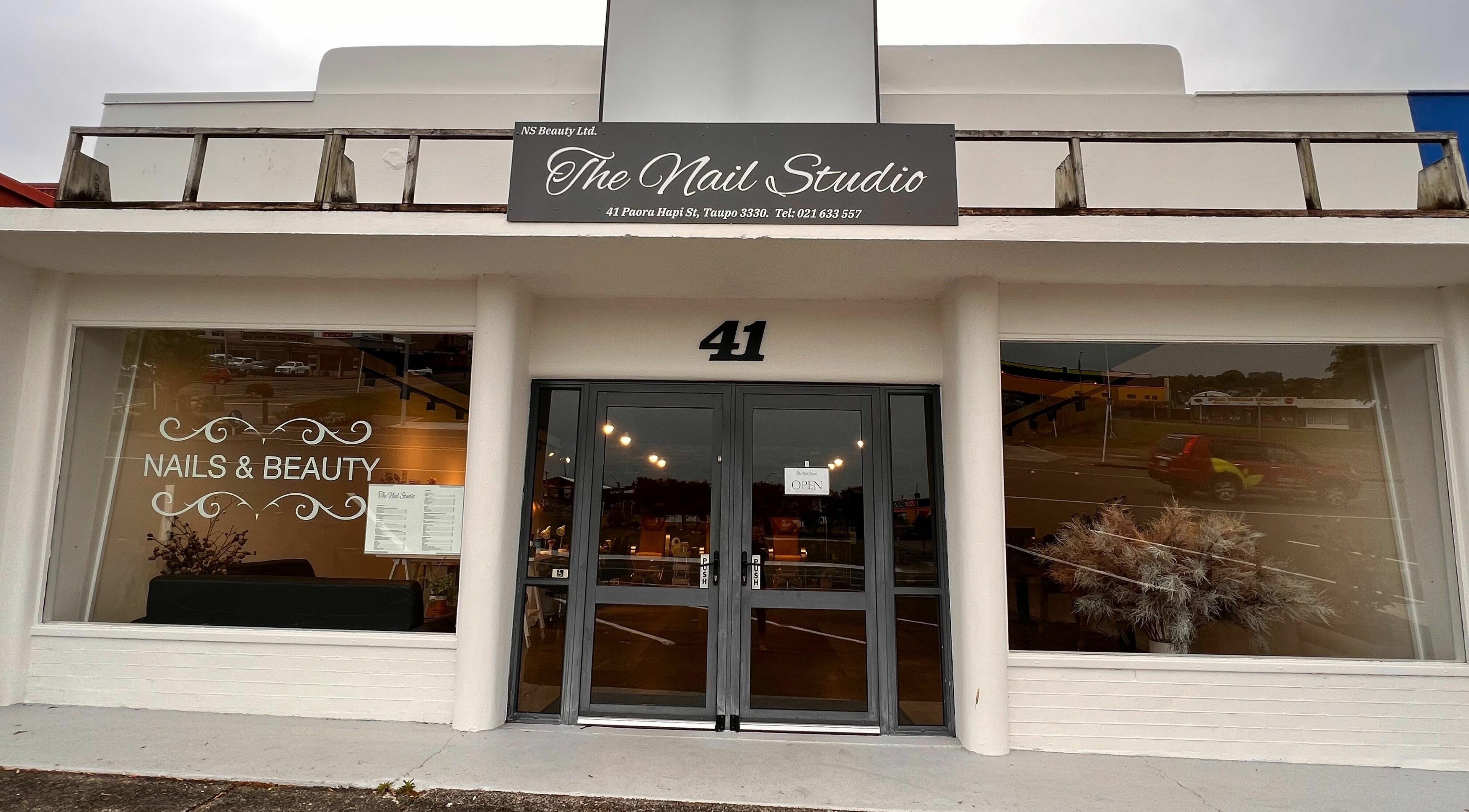 Entrance to The Nail Studio in Taupō, Waikato, NZ showcasing elegant glass doors and stylish signage.