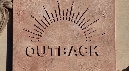 Artistic exterior signage of Outback Salon in Dunfermline, Scotland, GB, showcasing textured design.