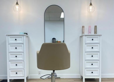 Modern hair salon station at Blonde Design Co., Mount Forest, Ontario, CA showcasing sleek mirrors and storage.