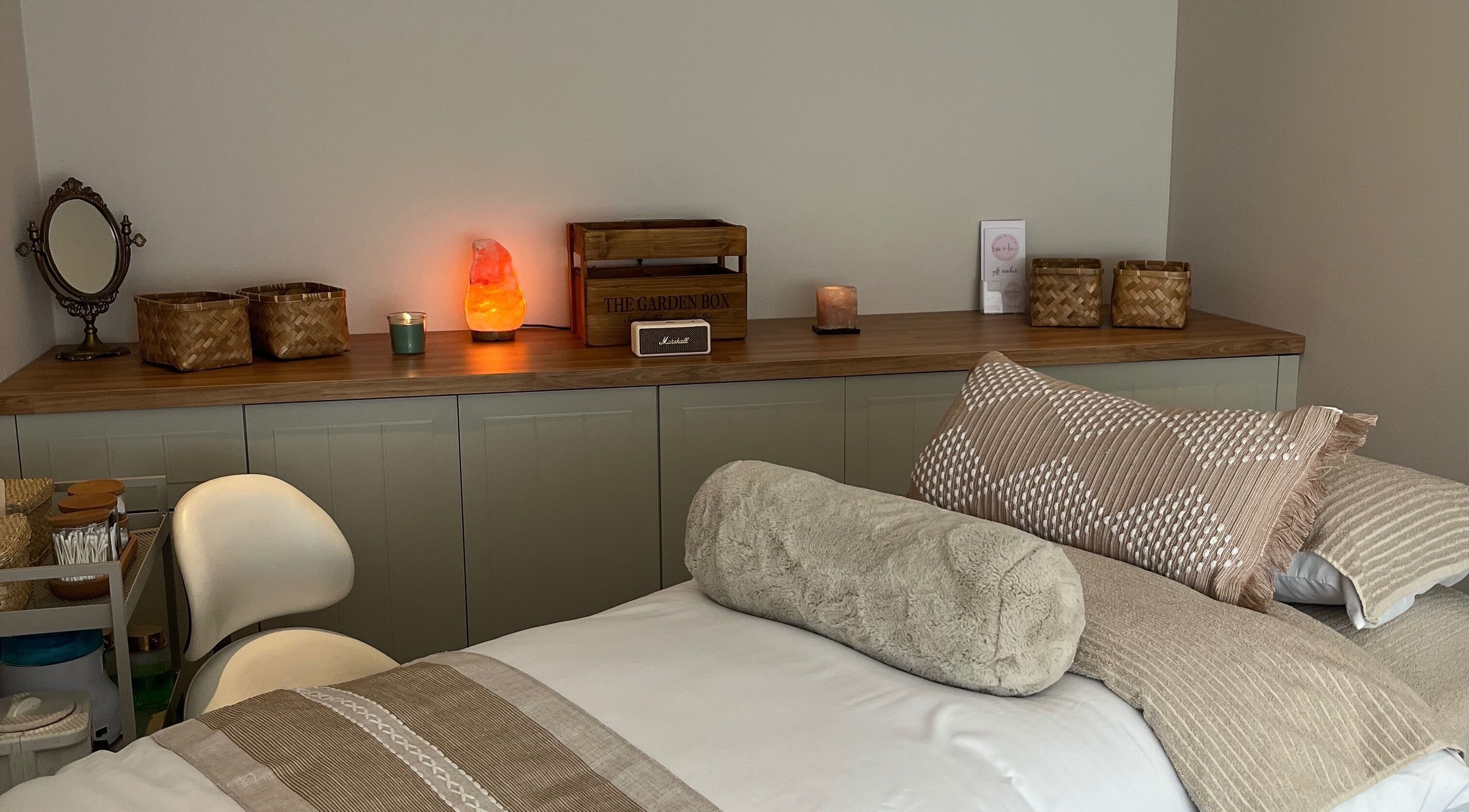 Cozy treatment room at Lisa Aien Beauty, Edinburgh, Scotland, GB, featuring warm decor and ambient lighting.