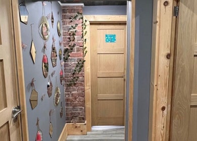 Elegant hallway at Nails by Liz in Leabrooks, England, GB, featuring stylish mirrors and brick elements.