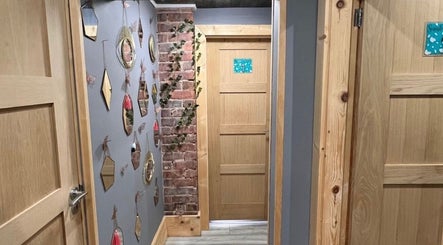 Elegant hallway at Nails by Liz in Leabrooks, England, GB, featuring stylish mirrors and brick elements.
