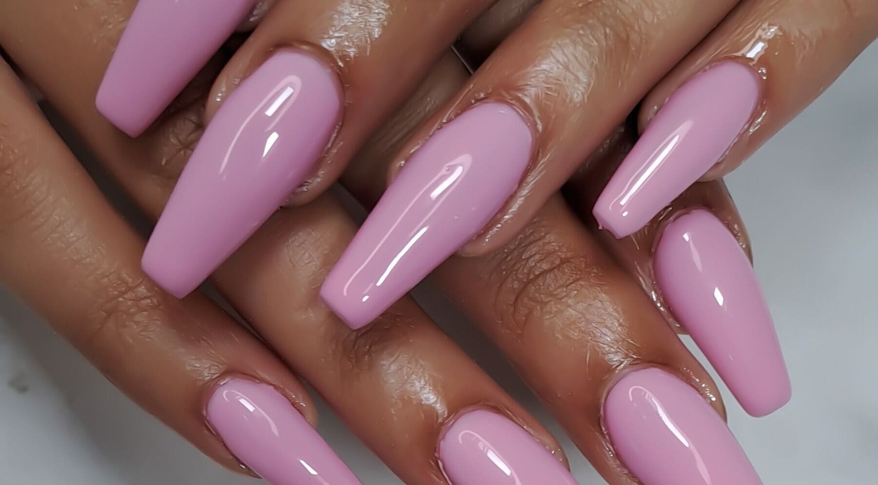 Glossy pink nails manicured at Minx nails & beauty, Cape Town, Western Cape, ZA. Stylish and elegant design.
