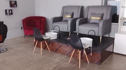 Área de pedicure elegante na Ezer Estética Lda, Matola, Maputo, MZ, com poltronas cinzas e bacias brancas.