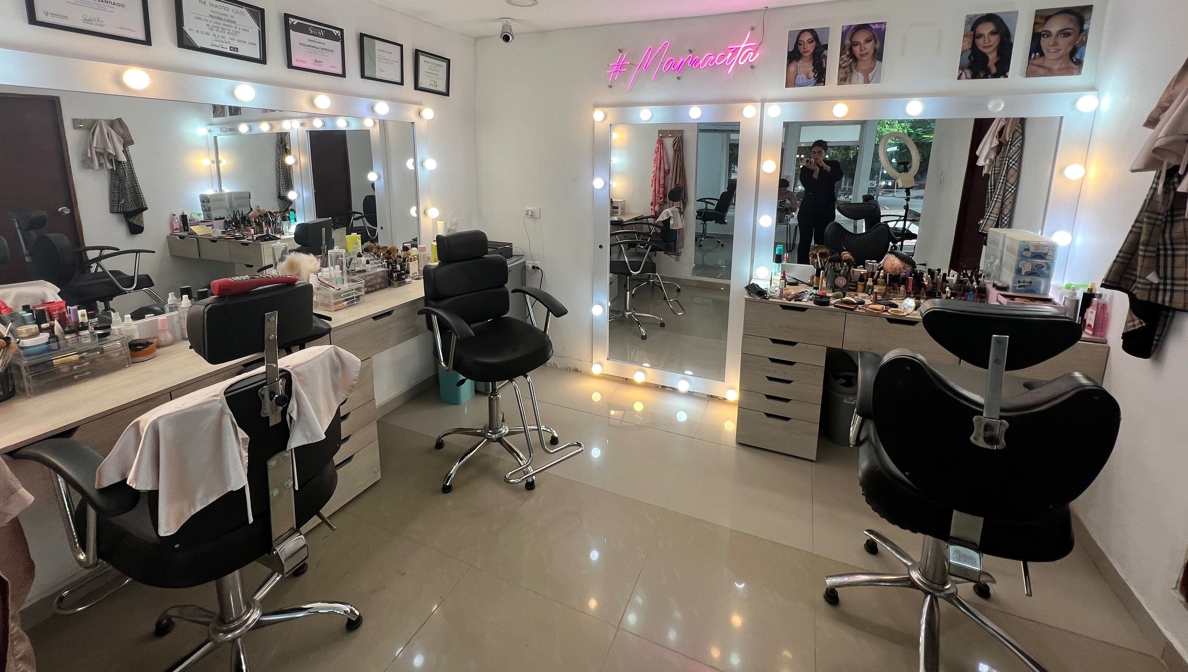Interior de Paola Bonilla Makeup Studio, Barranquilla, Cali, con espejos iluminados y sillas elegantes.