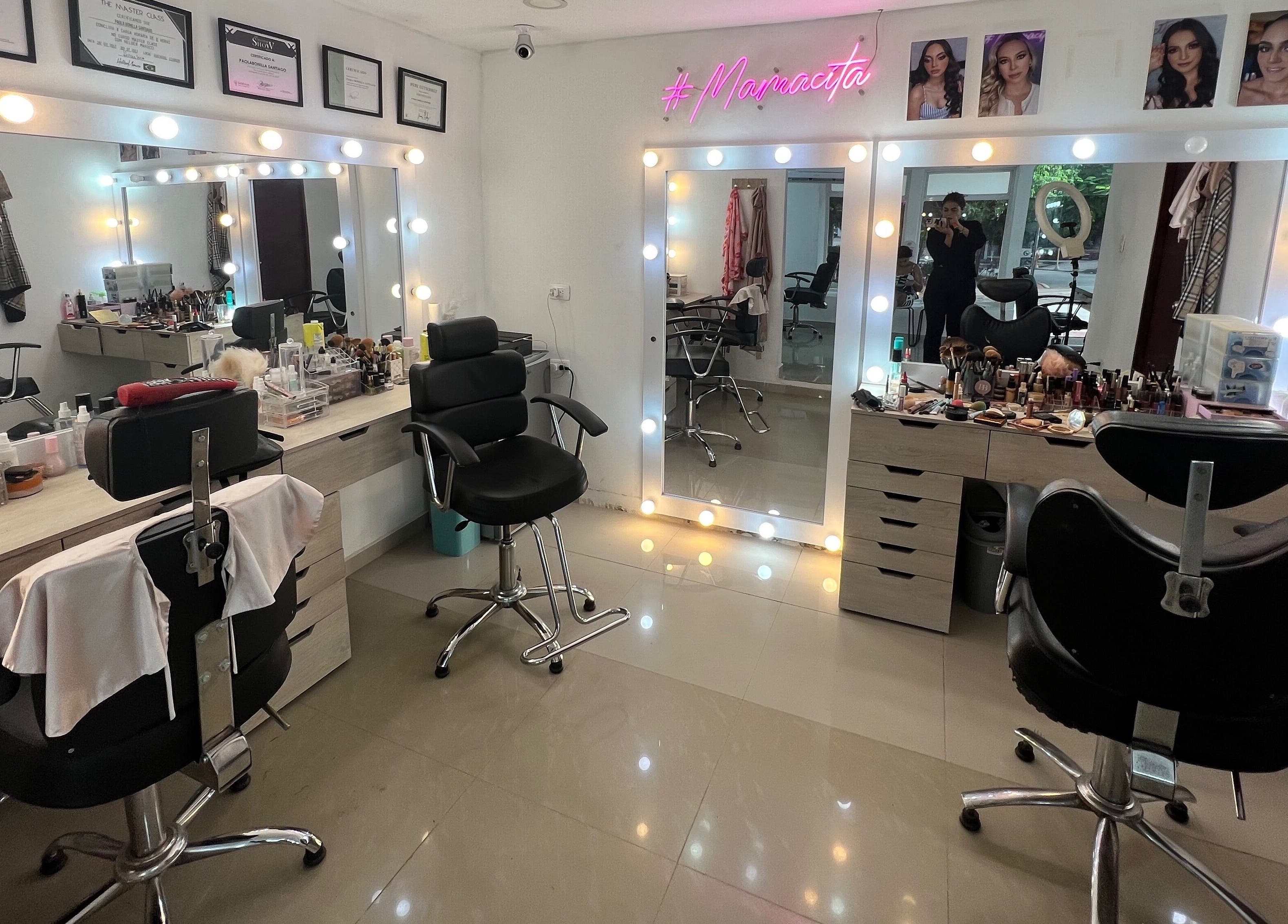Interior de Paola Bonilla Makeup Studio, Barranquilla, Cali, con espejos iluminados y sillas elegantes.