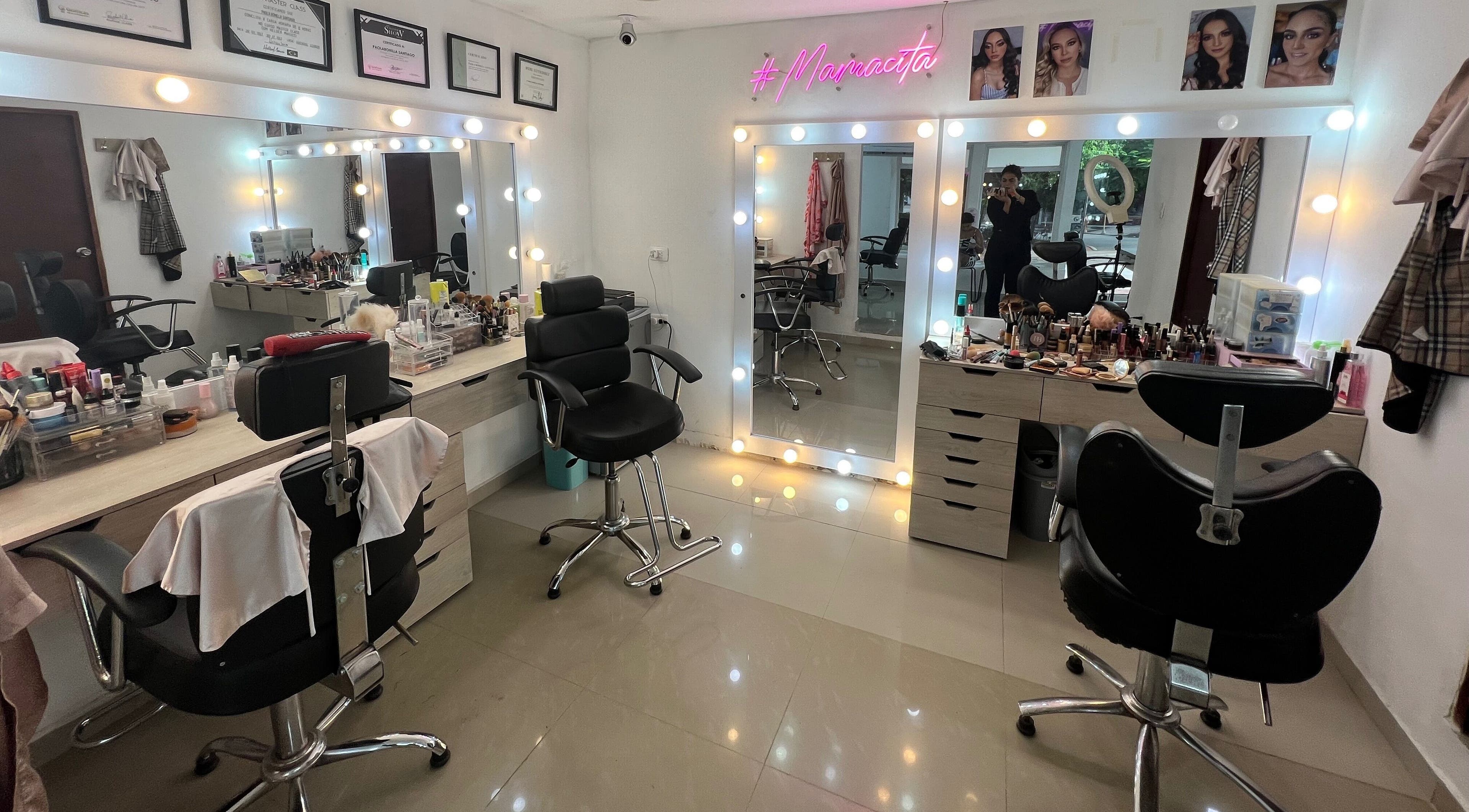 Interior de Paola Bonilla Makeup Studio, Barranquilla, Cali, con espejos iluminados y sillas elegantes.