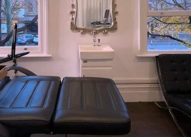 Modern treatment room at Cosmeticca Skin Clinic, Melbourne, Victoria, AU, featuring sleek black lounge chairs.