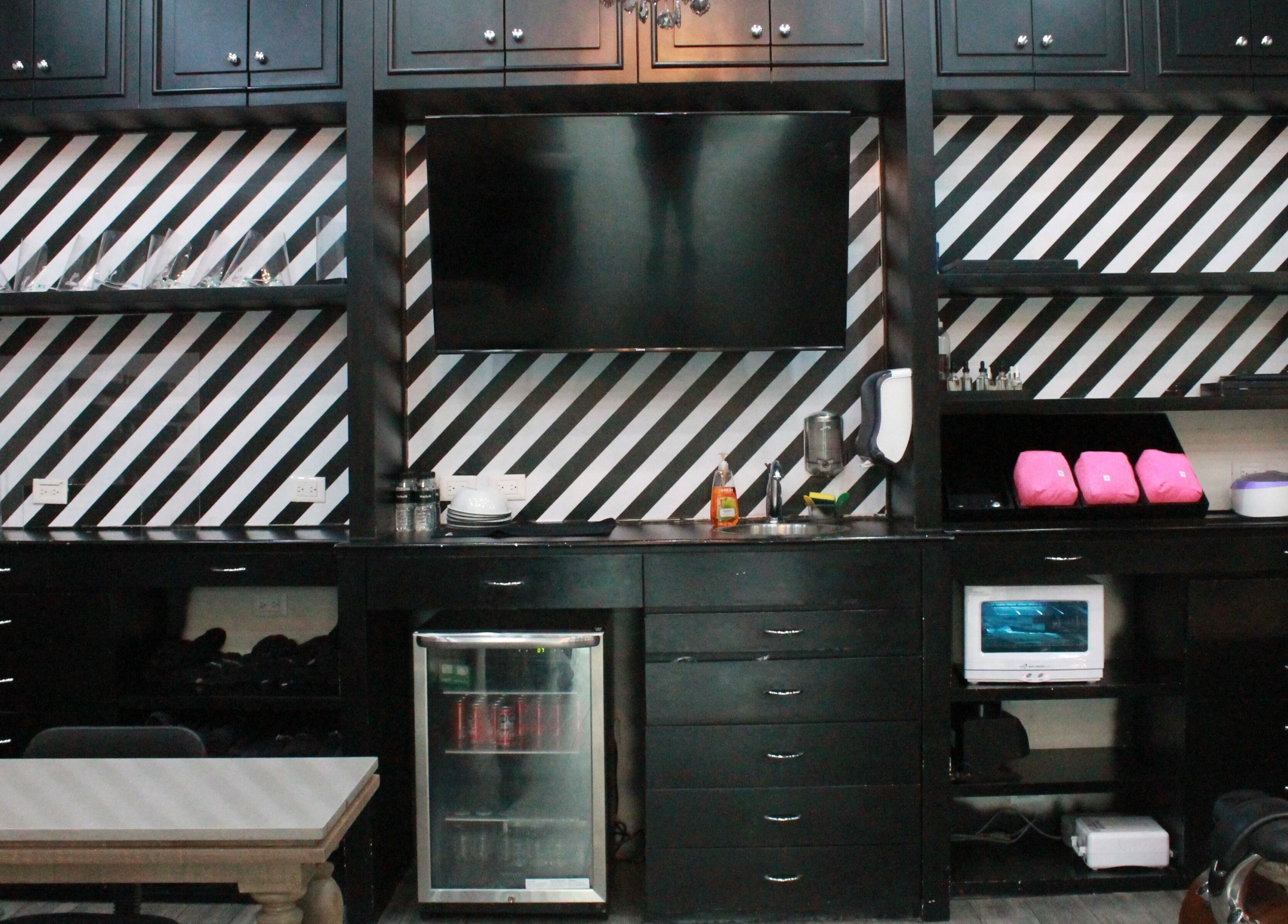 Interior elegante del Mackelli Nail Spa - Cumbres Elite en Monterrey, Nuevo León, MX con estantería moderna.