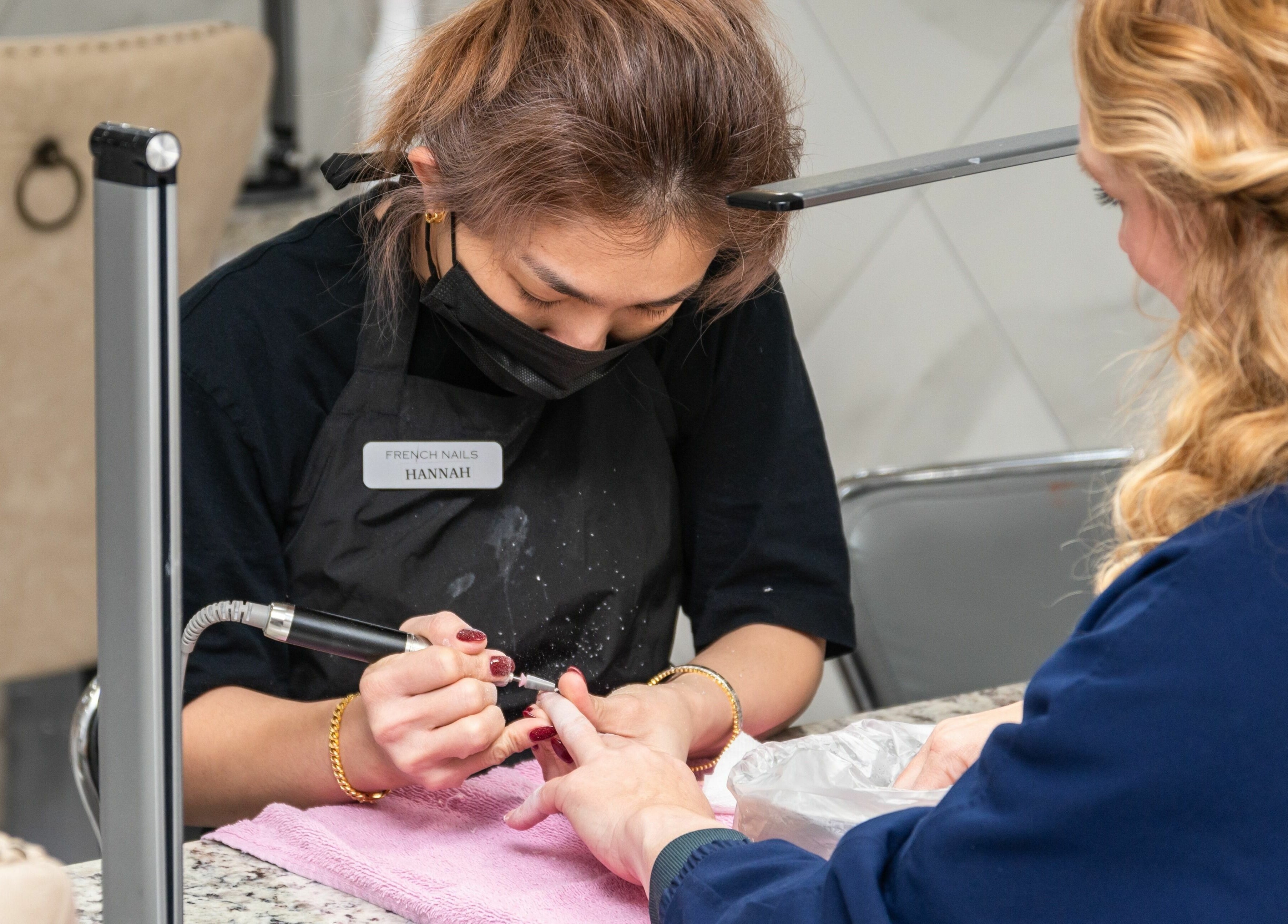 Expert manicure at French Nails Luxury Spa and Bar in Dallas, Texas, US, enhancing client nails with precision.