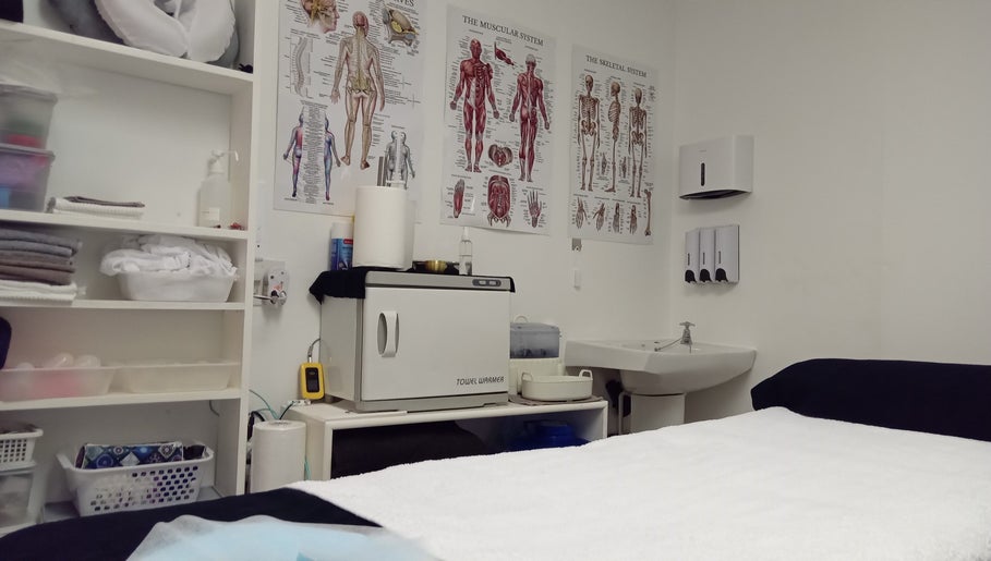 Sports Massage & Cupping Clinic therapy room in Durban North, Kwazulu-natal, ZA with anatomical charts.