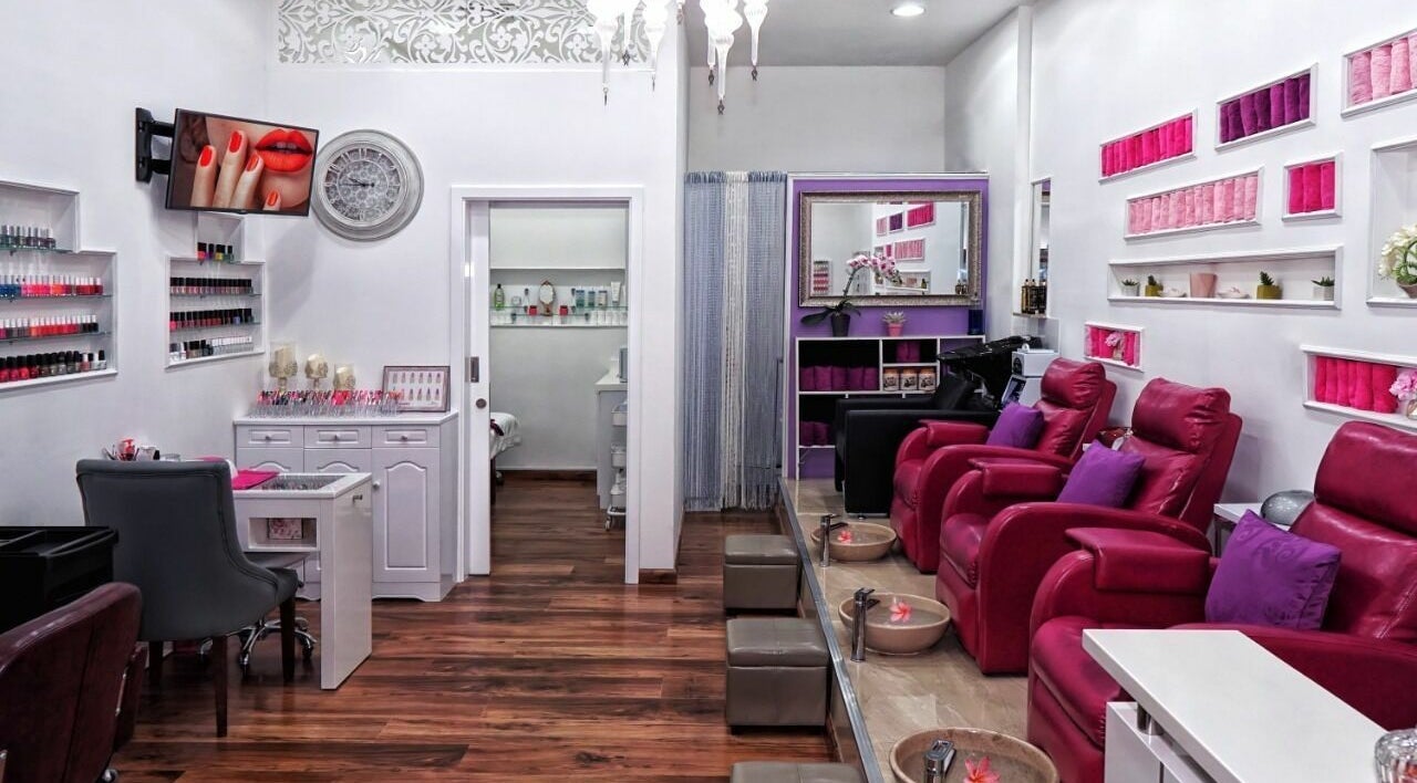 Elegant interior of Nail Trix Salon in Dubai, AE, featuring plush chairs and vibrant nail polish display.