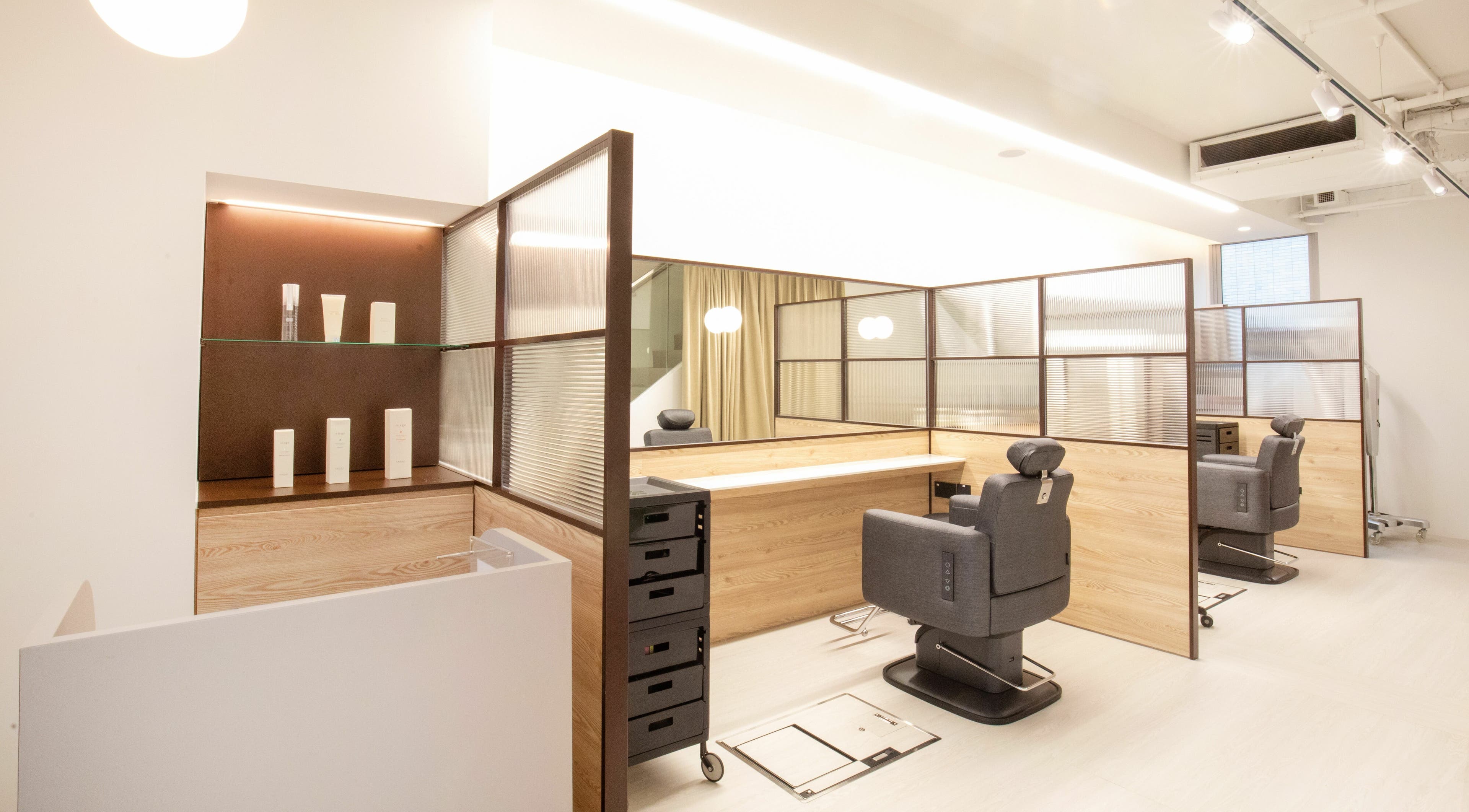 Modern salon interior of TCL Beauty Studio in Singapore, Singapore, SG with stylish chairs and wooden partitions.