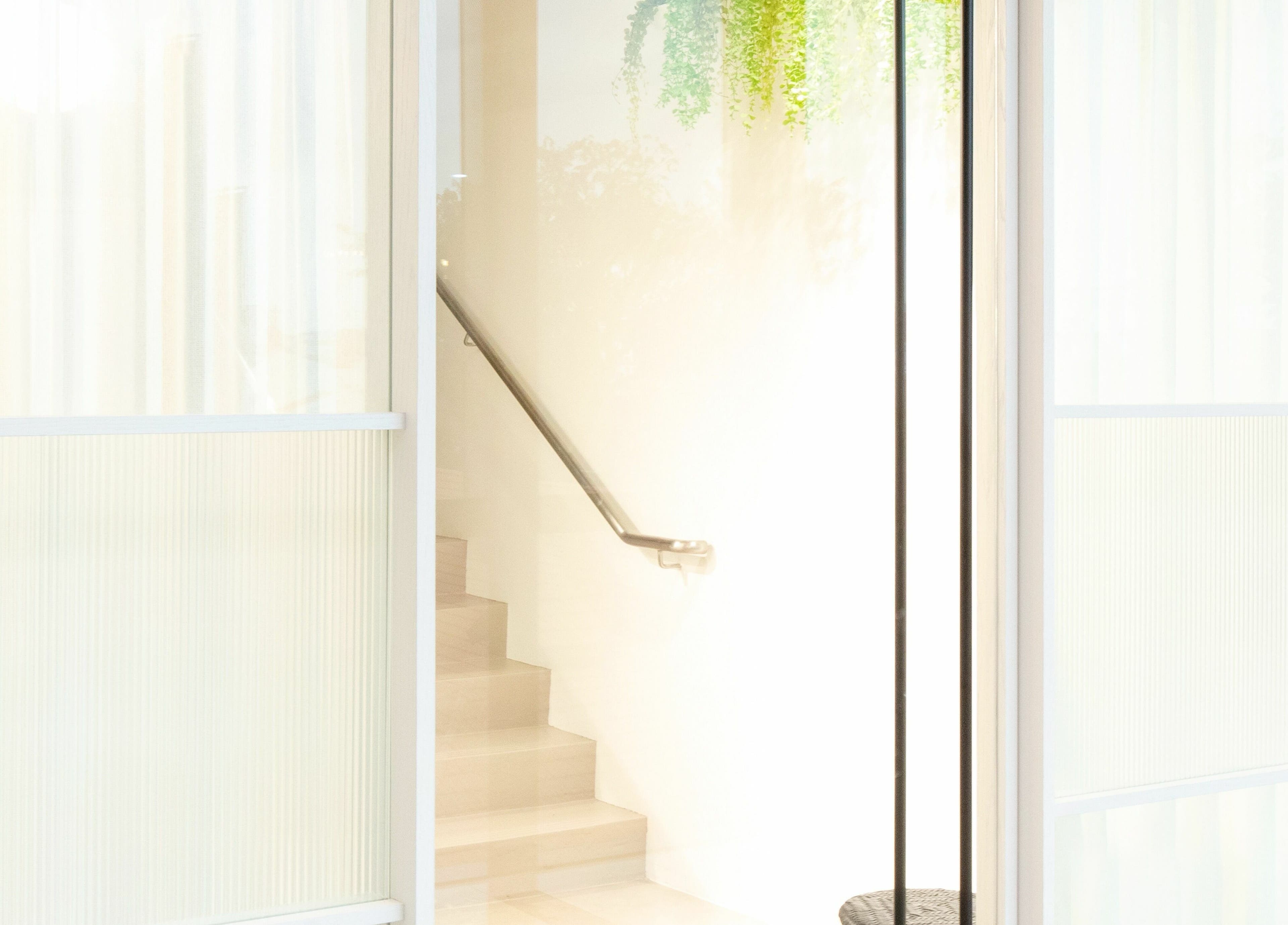 Bright staircase entrance at TCL Beauty Studio, Singapore, SG with modern design and greenery.