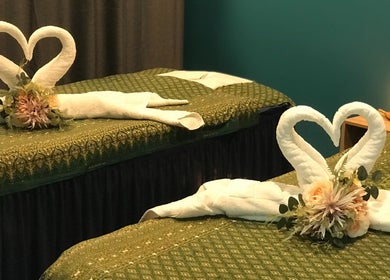 Elegant towel swans on massage beds at Naree Thai Massage in Auckland, NZ, creating a serene ambiance.