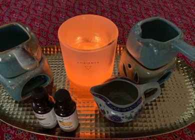 Aromatherapy setup at Naree Thai Massage in Auckland, NZ with essential oils and a glowing candle.