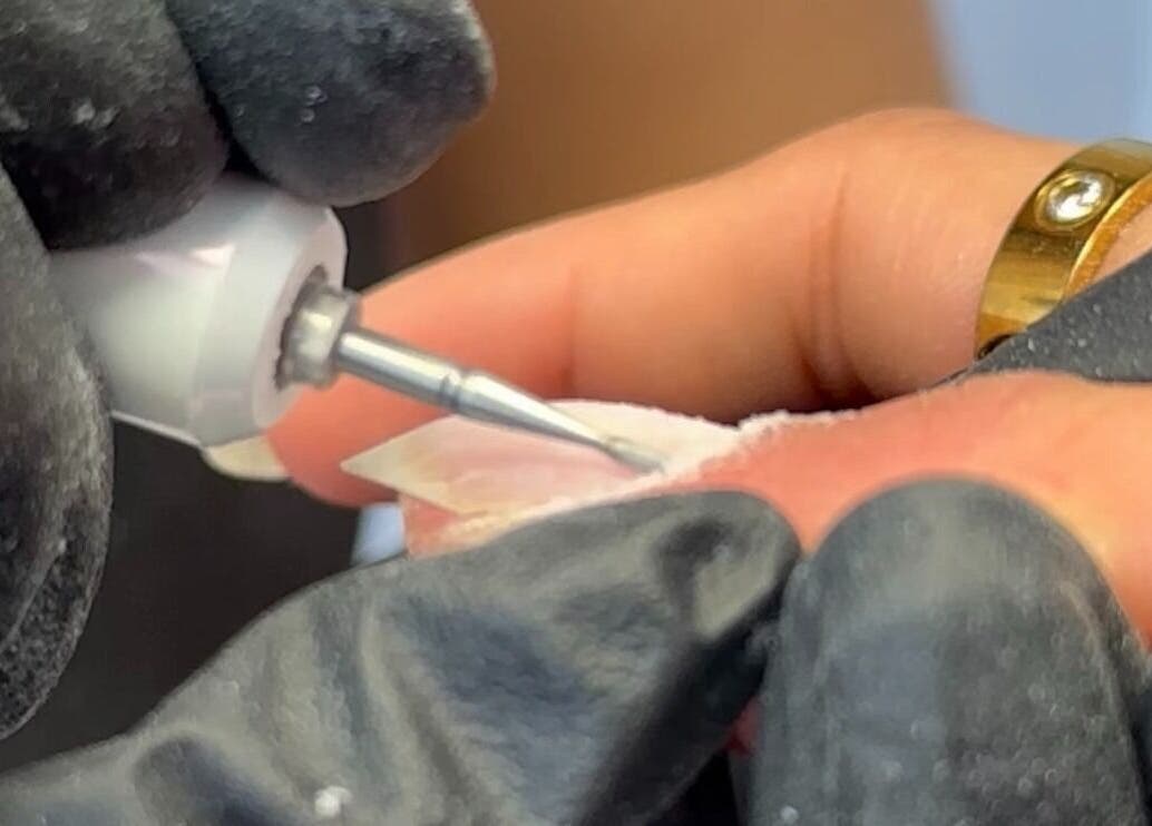 Nail technician shaping a nail at EKM Nails, Main Beach, Queensland, AU.