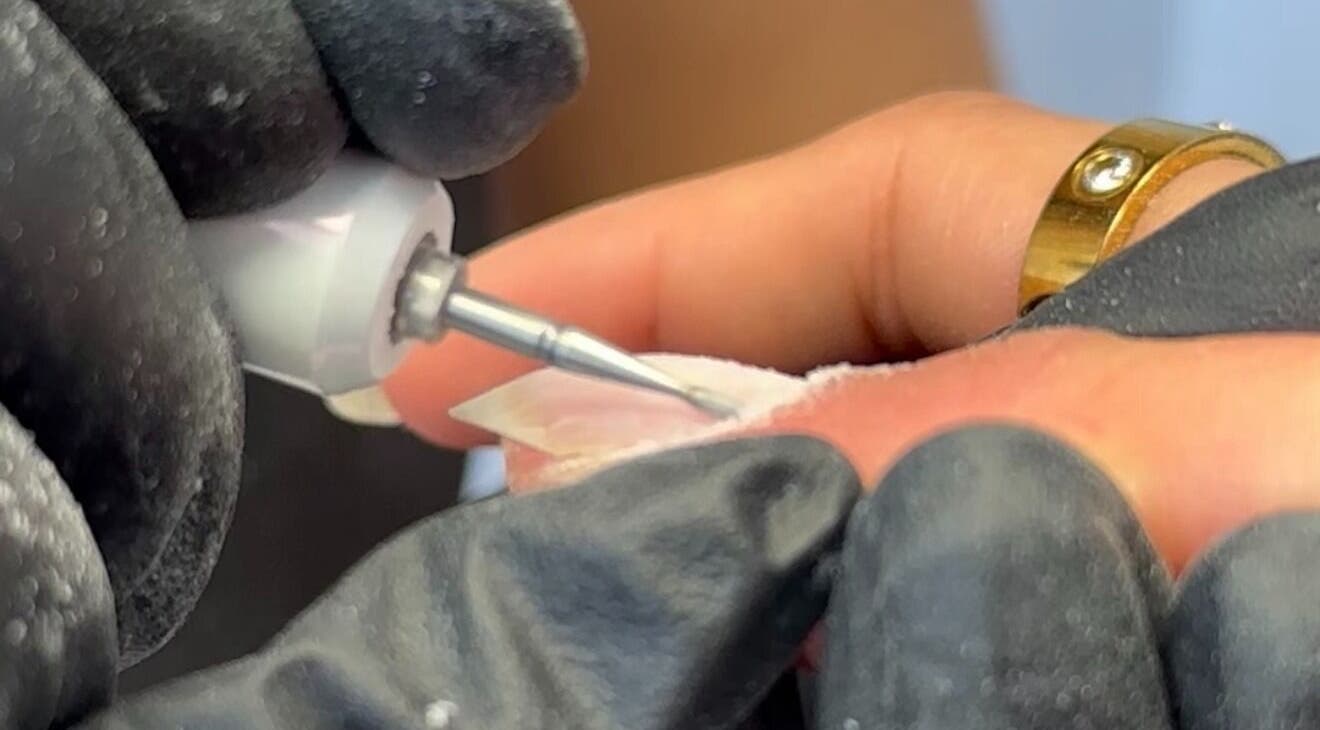 Nail technician shaping a nail at EKM Nails, Main Beach, Queensland, AU.