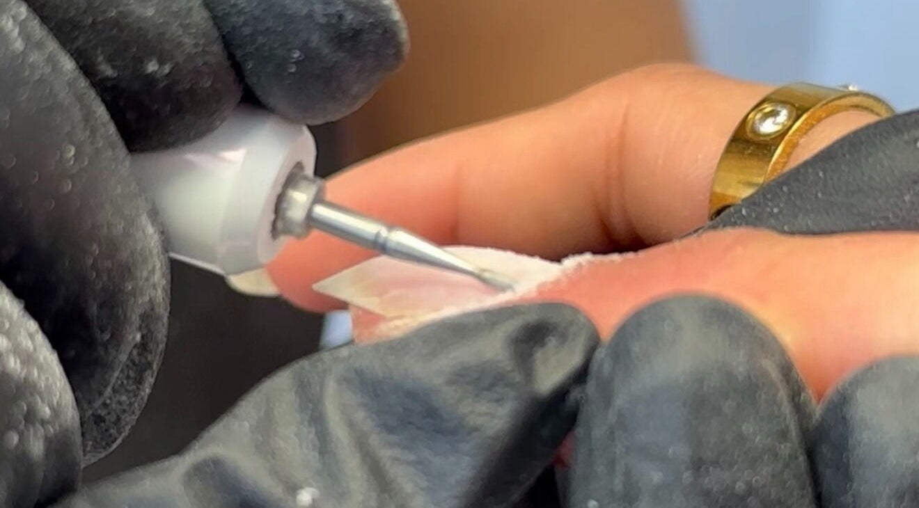 Nail technician shaping a nail at EKM Nails, Main Beach, Queensland, AU.