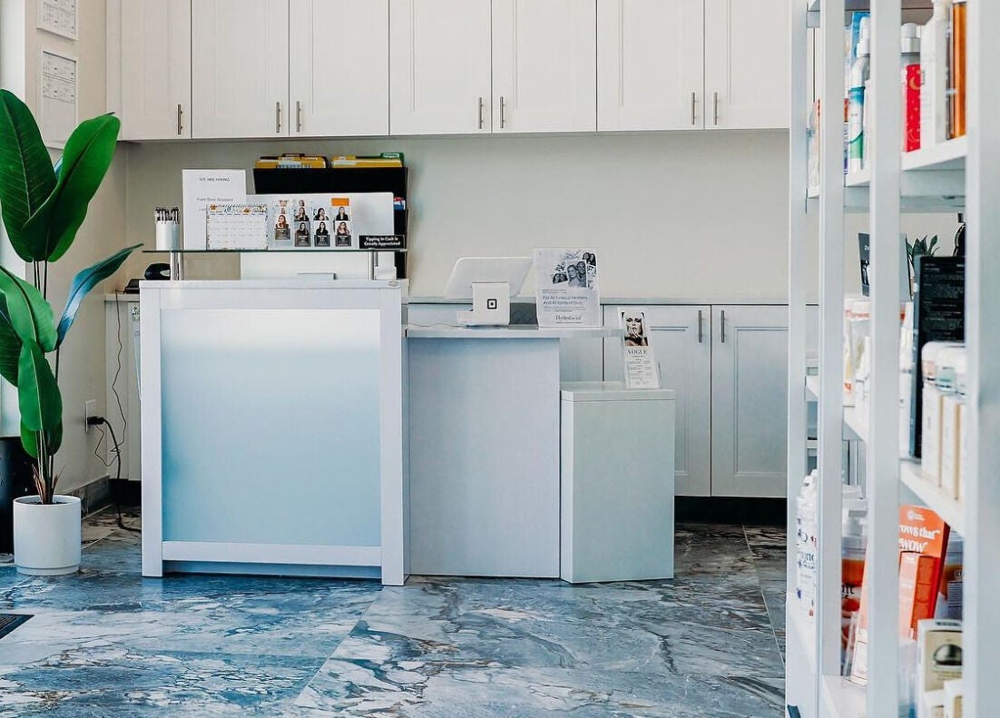 Reception area at Vogue Lashes & Spa - Greenbrier, Chesapeake, Virginia, US with modern decor and open shelving.